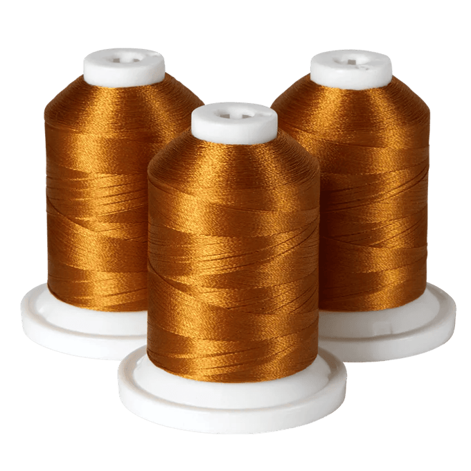 Three spools of golden embroidery thread on white bases for Brother sewing machines