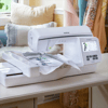 Brother embroidery machine with touchscreen display and fabric hoop on white table