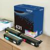 Brother TN431 3-pack color toner cartridges with packaging on desk beside printer