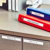 Organized office desk with labeled binders and file drawers for document management