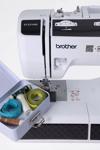 Brother ST371HD sewing machine with measuring tapes and thread spools in storage box
