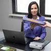 Woman receiving labeled binder with Brother PT-D410VP portable label maker on desk