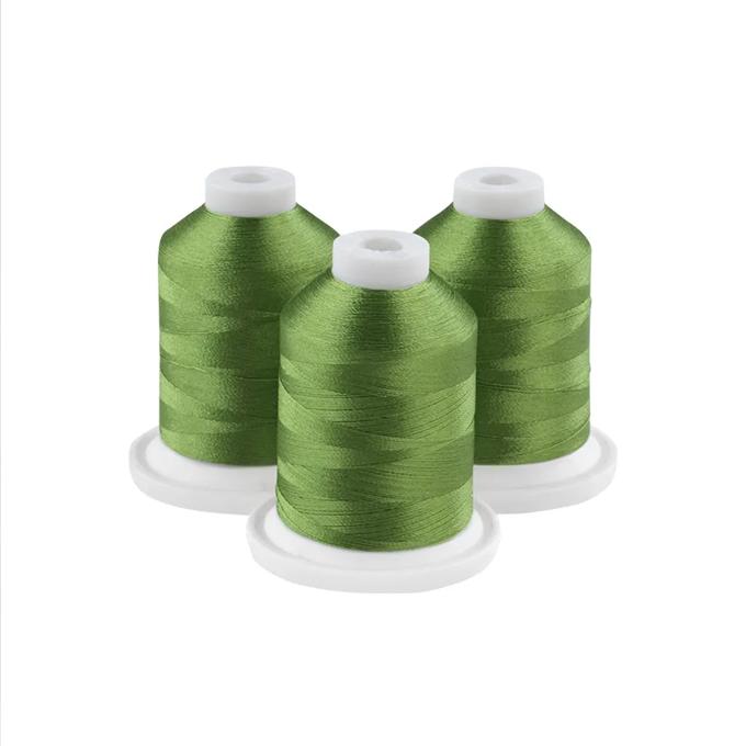 Three meadow green embroidery thread spools with white caps on circular bases