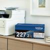 Brother TN227 2-pack toner cartridge box on desk beside wireless all-in-one printer