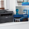 Brother all-in-one laser printer with TN770 high-yield toner cartridge on home office shelf