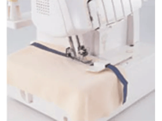Brother serger sewing machine stitching fabric with navy blue thread on white surface