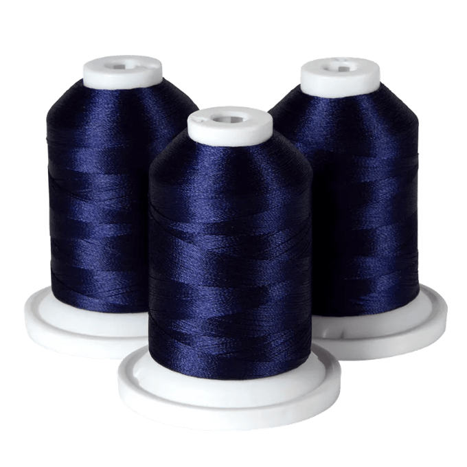 Three spools of navy blue embroidery thread on white bases