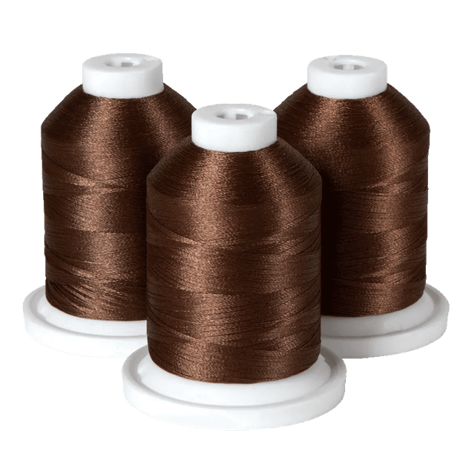 Three spools of brown Brother embroidery thread on white bases