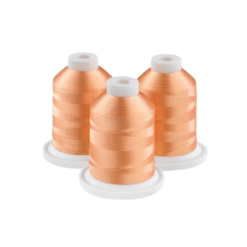 Three spools of mellow melon embroidery thread on white bases