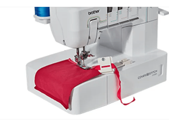 Brother cover stitch machine sewing red fabric with visible needle and thread
