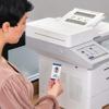 Person using NFC card authentication on Brother MFC-EX915DW all-in-one printer