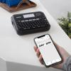 Brother P-touch wireless label maker with QWERTY keyboard and smartphone app on white desk