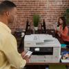 Man using smartphone to print with Brother all-in-one printer in office setting