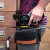 Brother label maker in tool belt with hand reaching for mobile printer