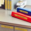 Brother label maker organizing office binders on desk with labeled file folders
