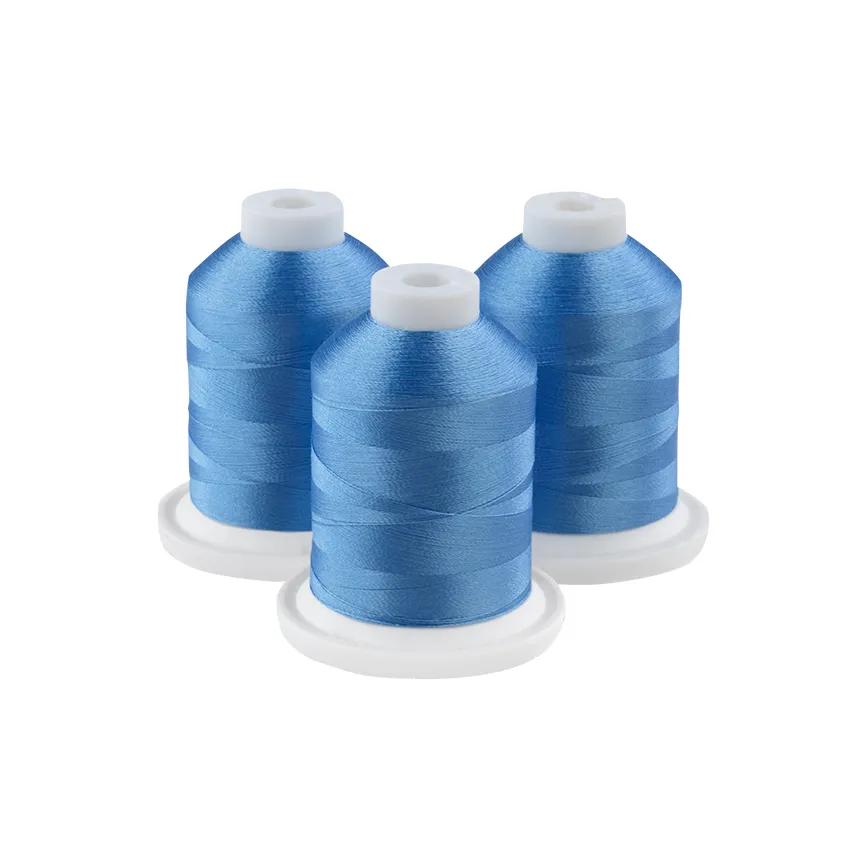 Three glacier blue embroidery thread spools on white bases