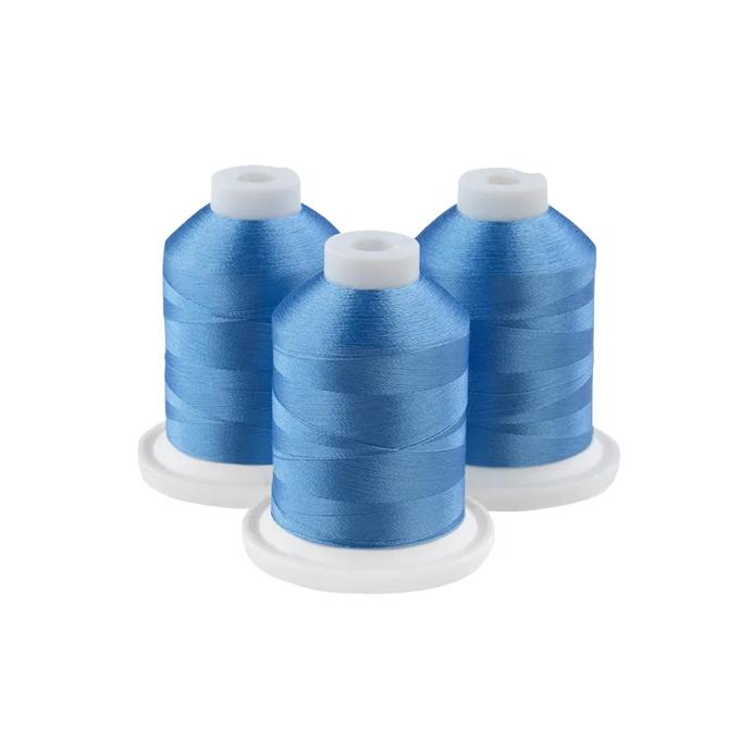Three glacier blue embroidery thread spools on white bases