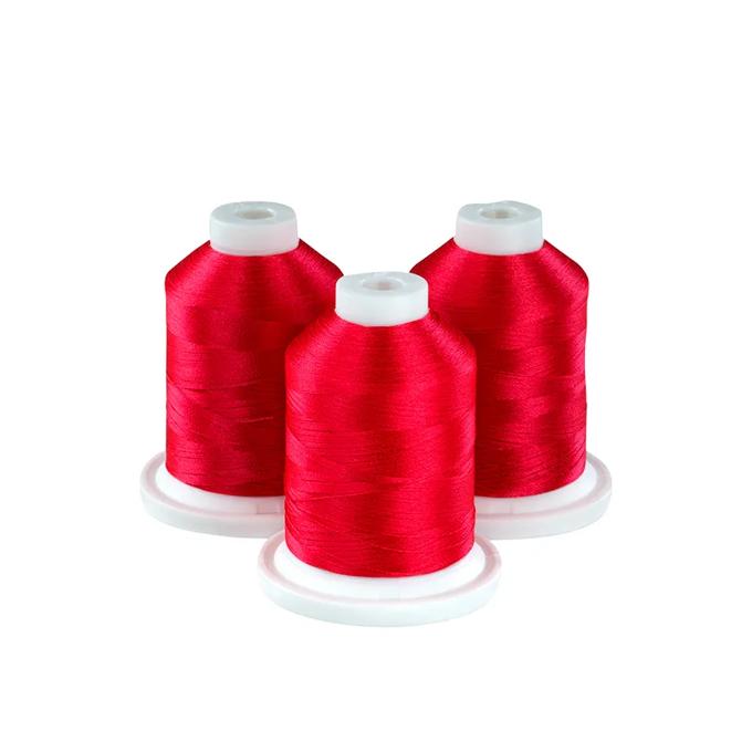 Three spools of vibrant red embroidery thread on white bases