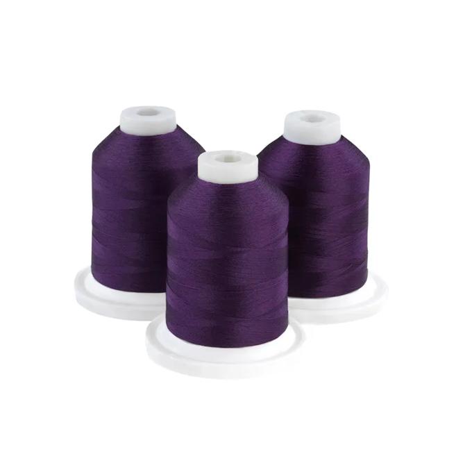 Three purple embroidery thread spools on white bases