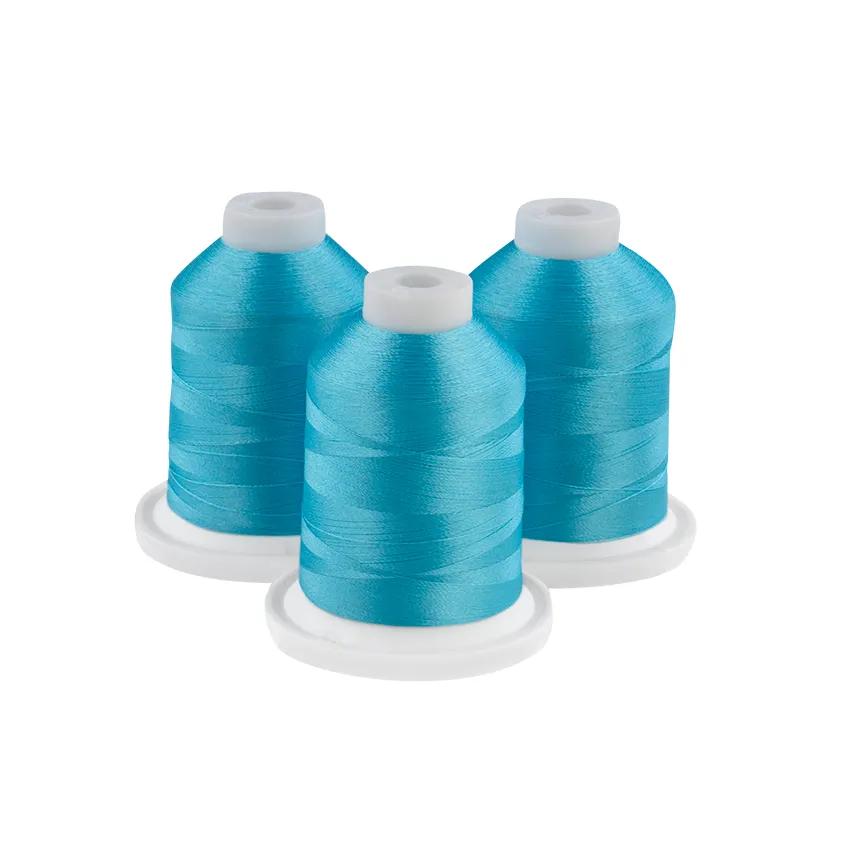 Three teal embroidery thread spools on white bases