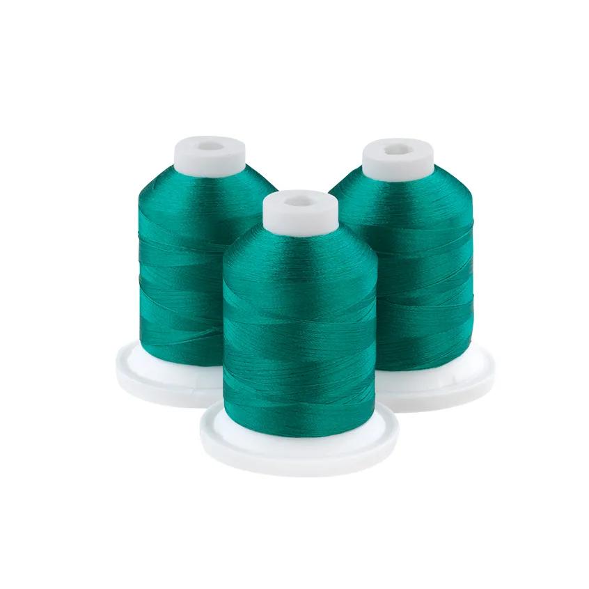 Three teal embroidery thread spools on white bases