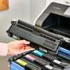 Hand installing Brother black toner cartridge into color laser printer