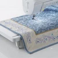 Brother sewing machine stitching blue floral fabric with decorative embroidery pattern