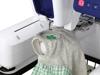 Brother embroidery machine stitching shamrock design on gray fabric in hoop