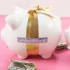 White piggy bank wrapped with gold glitter ribbon and Brother TZe premium label tape