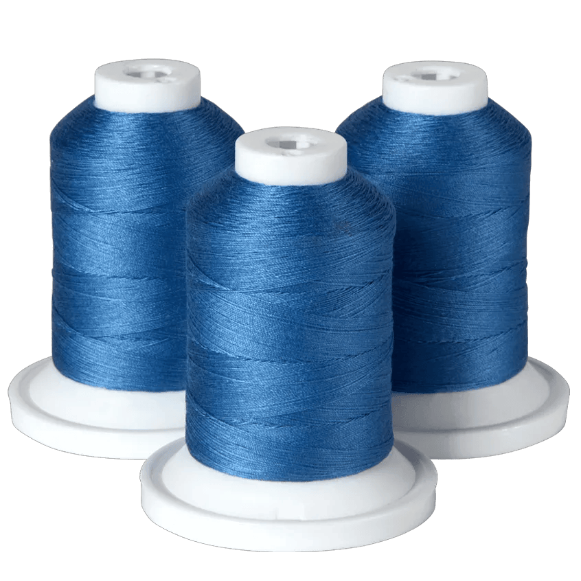 Three spools of blue embroidery thread on white bases