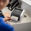Brother TD-4410D desktop label printer printing barcode shipping label in warehouse setting