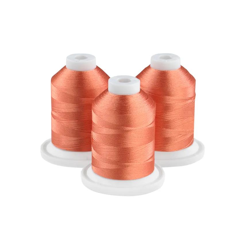 Brother embroidery thread spools in melon color with white caps on white bases