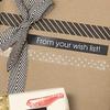 Cinta de etiquetas Brother TZe-345 en caja de regalo envuelta con listón a rayas blanco y negro