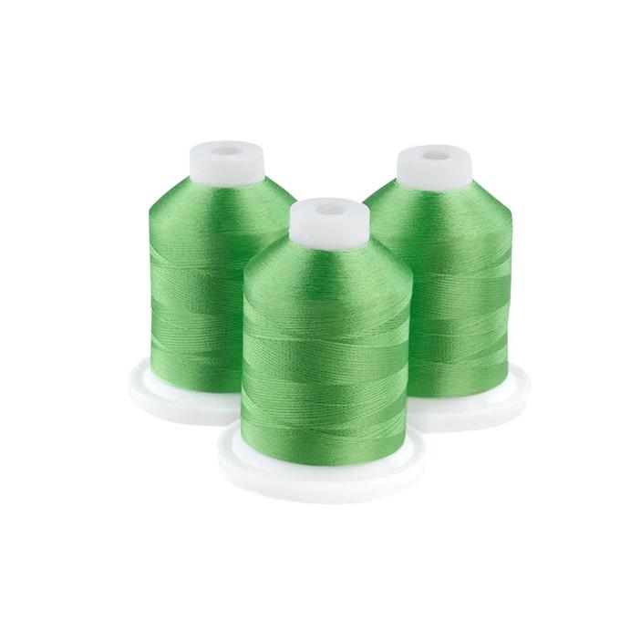 Three valley green embroidery thread spools on white background