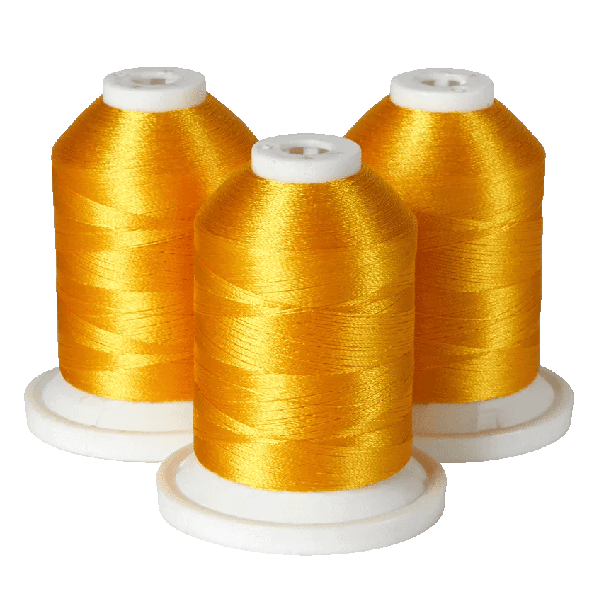 Three spools of golden yellow embroidery thread on white bases