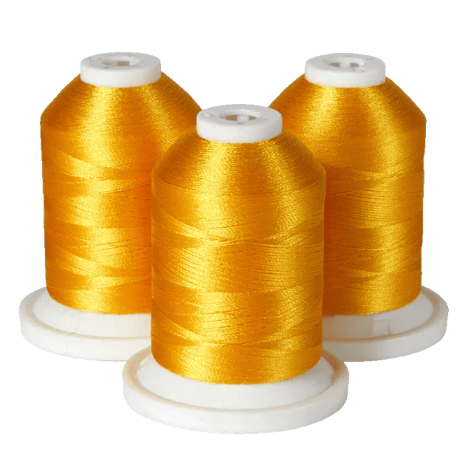 Three spools of golden yellow embroidery thread on white bases