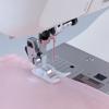 Brother sewing machine presser foot stitching pink fabric with guide markings