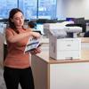 Woman using Brother MFC-EX915DW all-in-one laser printer in modern office environment