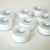 Brother sewing machine bobbins with white thread on neutral surface
