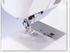 Brother sewing machine needle and presser foot stitching white fabric