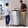 Two office workers using Brother multifunction printer with high-capacity paper trays