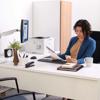 Woman reviewing documents at desk with Brother HL-L5210DN monochrome laser printer in office