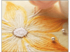 Close-up of yellow embroidered flower with metallic beads on fabric