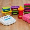 Brother label maker organizing colorful children's storage containers on wooden surface
