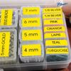 Brother TZe label tape organizer with color-coded laminated tapes in various widths