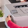 Hand inserting USB into Brother HL-L8570CDW color laser printer with touchscreen display