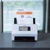 Brother ADS-4900W desktop scanner with touchscreen scanning a document in an office setting