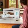 Man using Brother Stellaire XE2 embroidery machine with touchscreen at home workspace