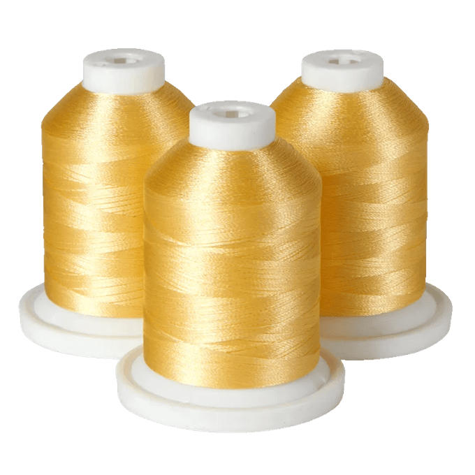 Three spools of golden yellow embroidery thread on white bases