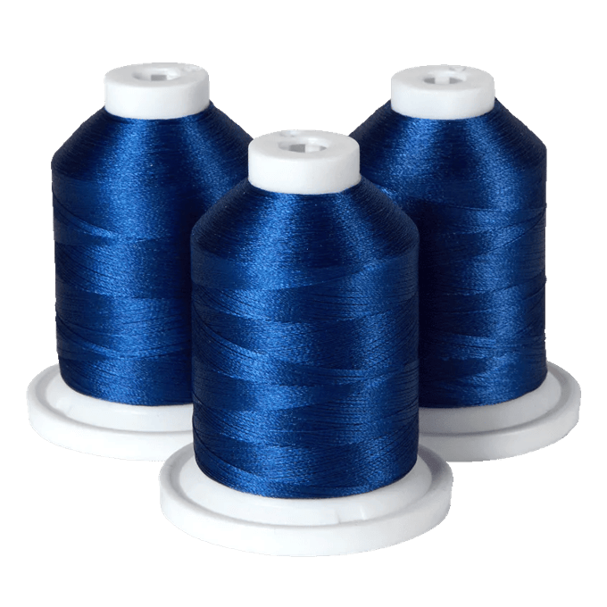 Three spools of Brother royal blue embroidery thread on white bases